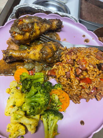 Jerk chicken drumsticks served with jambalaya and steamed vegetables