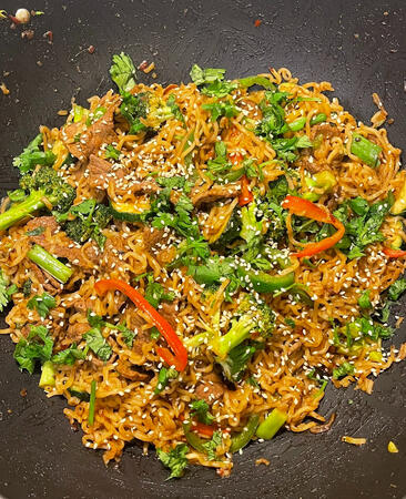 Beef stir-fry noodles with broccoli, peppers, zucchini, jalapeños, green onions, and cilantro