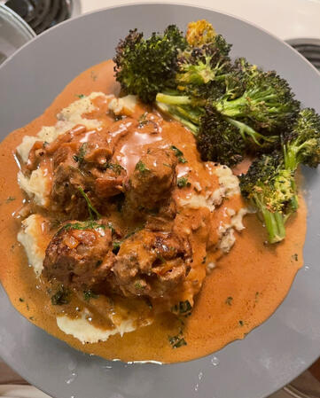 Slow-cooked beef meatballs in gravy served over garlic mashed potatoes and roasted broccoli