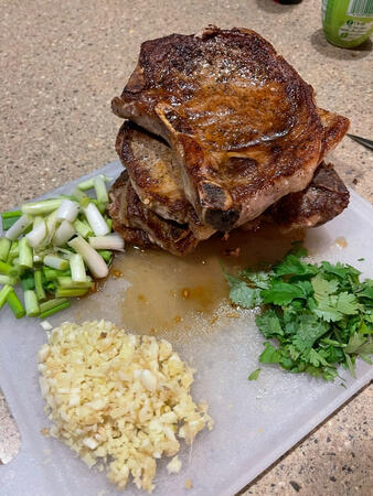 Asian seared pork chops with fresh green onions, cilantro, and garlic